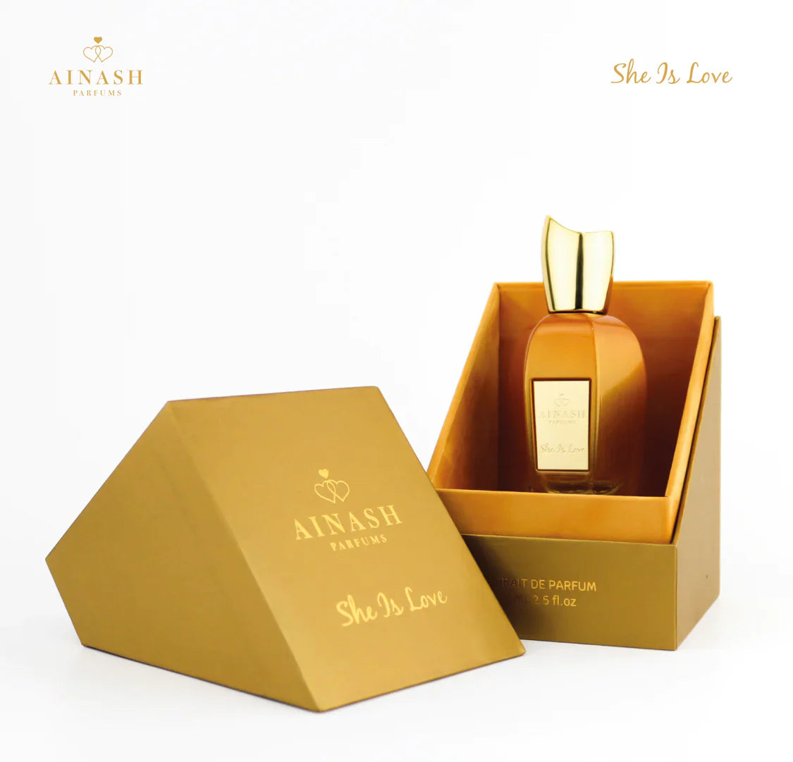 Ainash Parfums 'She Is Love' perfume bottle in a gold box on a white background