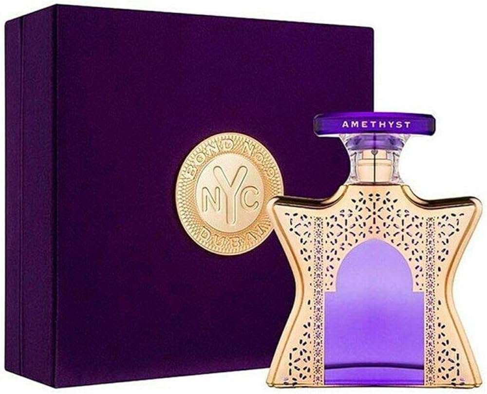 A purple bottle of Bond No 9 Dubai Amethyst 3.4 Edp with a gold cap, alongside its box and a decorative element.